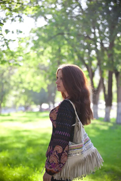 Young woman with bag walking at the summer park — Stock Photo, Image