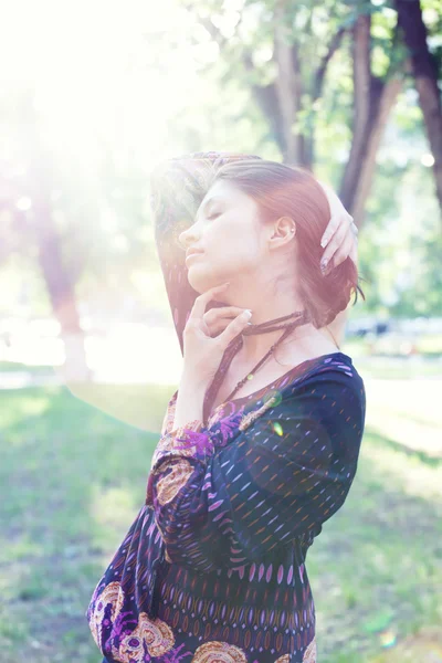 Young woman enjoys sun beams at spring park — Stock Photo, Image