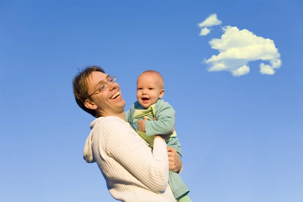 Отец держит ребенка в руках на закате — стоковое фото