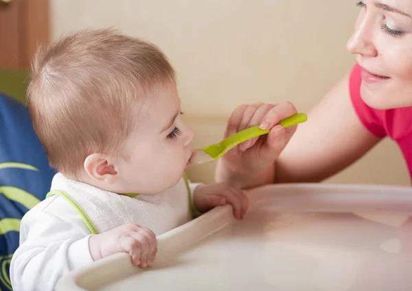 Retrato de una joven alimentando a su bebé — Foto de Stock