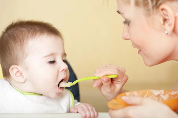 Bebeğini besleyen genç bir kadın portresi