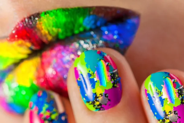 Lábios de mulher com belas unhas Minx multicoloridas e maquiagem — Fotografia de Stock