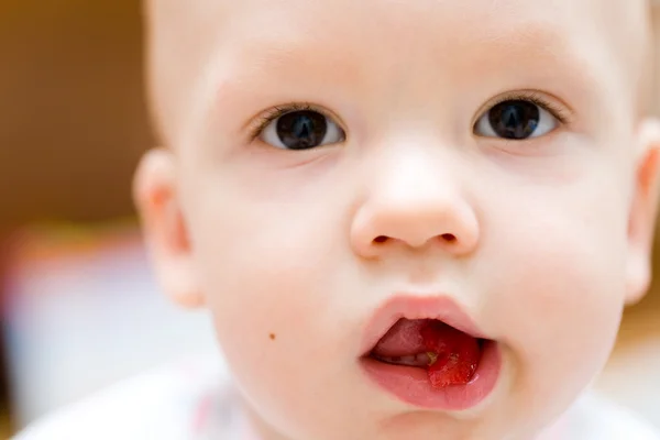 Baby spiser æble. Børns ansigt close-up - Stock-foto