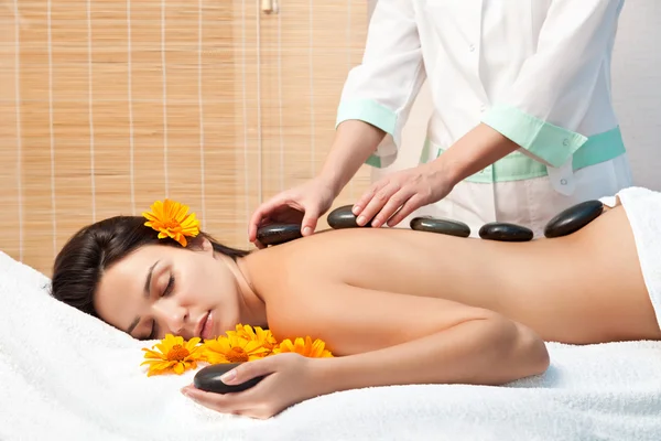 Mulher recebendo uma massagem de pedra quente no salão de spa — Fotografia de Stock
