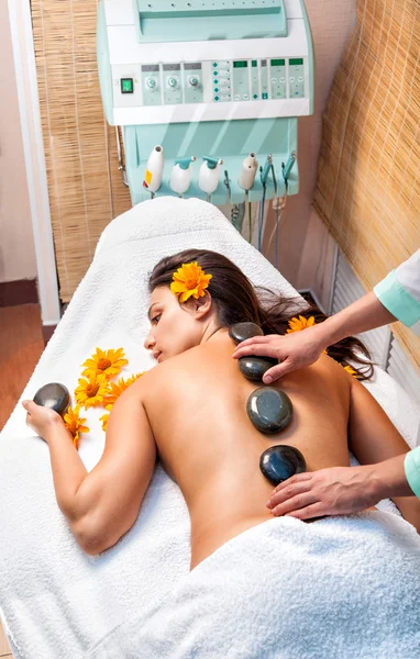 Sten terapi. Kvinna att få en hot stone massage i spasalong — Stockfoto