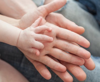 Baba ve anne çocuğun elini tutarak
