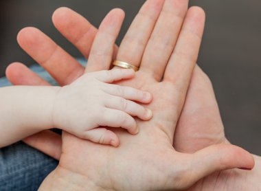 Baba ve anne çocuğun elini tutarak