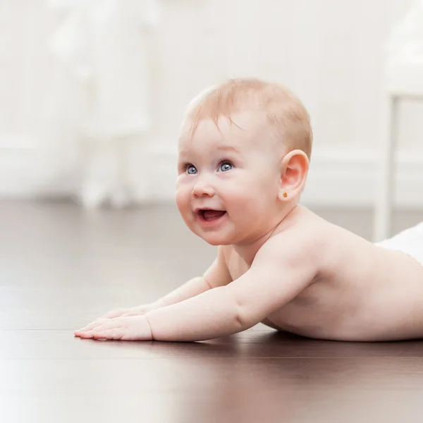 快乐七个月大女婴在硬木地板上爬 — 图库照片