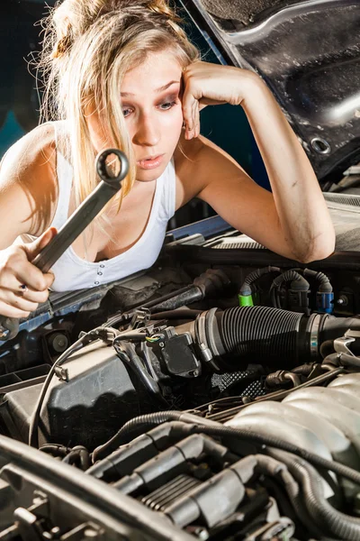 Chica desconcertada tratando de reparar su propio coche roto — Foto de Stock