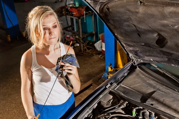Girl checks the oil level in the car — Stock Photo, Image