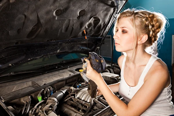 Girl checks the oil level in the car — Stock Photo, Image