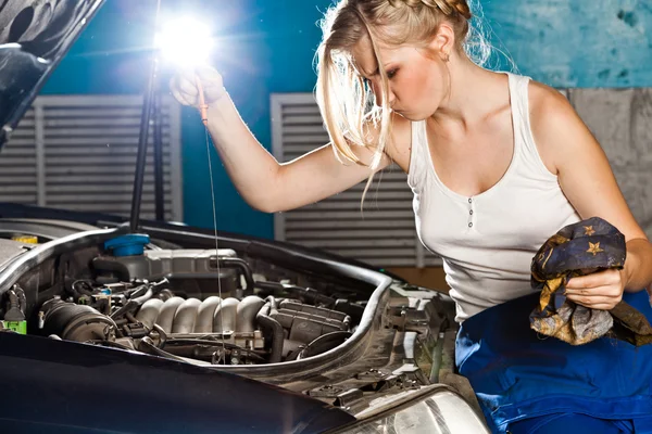 Chica comprueba el nivel de aceite en el coche — Foto de Stock