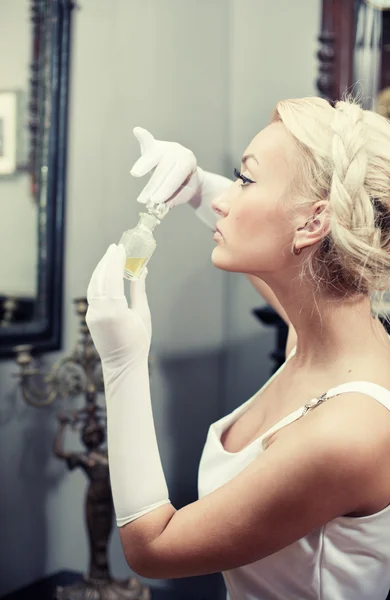 Porträtt av vacker ung kvinna att lukta en flaska parfym — Stockfoto