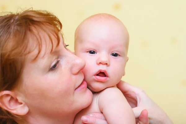 Mãe segurando suavemente o bebê nas mãos — Fotografia de Stock