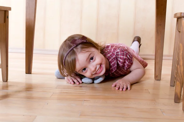 Feliz niña arrastrándose en el suelo de madera — Foto de Stock