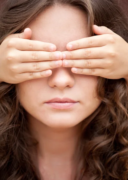 Younger sister closed eyes of her older sister by hands — Stock Photo, Image