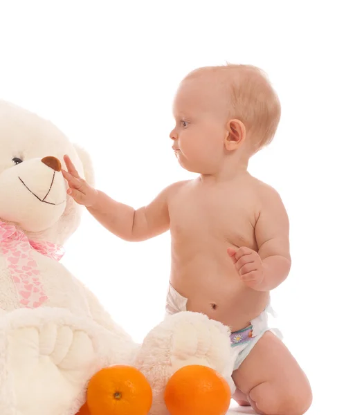 Portrait of adorable baby boy bring two oranges to favorite bear — Stock Photo, Image