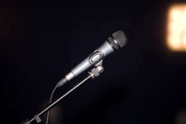 Микрофон в воздухе над черной сценой — стоковое фото