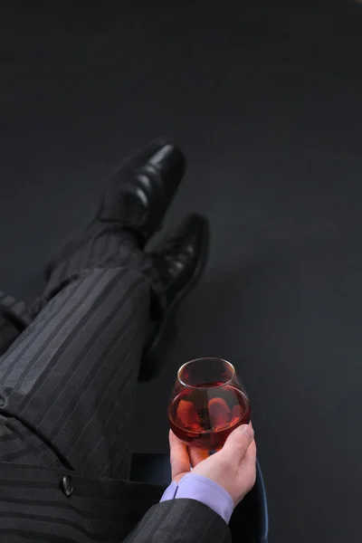 Бизнесмен расслабляется со стаканом коньяка — стоковое фото