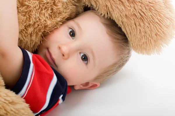 Pequeño niño lejía en blanco cama y abrazo juguete oso —  Fotos de Stock