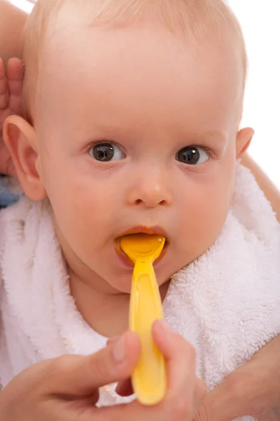 Mor fodrer sin baby søn ved hjælp af ske - Stock-foto