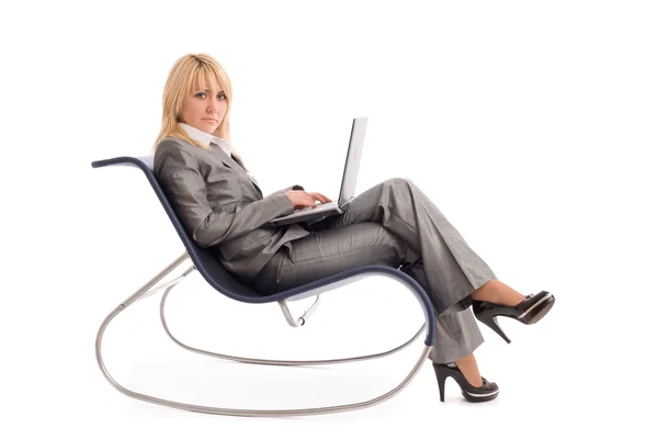 Geschäftsfrau mit Laptopauflage im Stuhl über Weiß — Stockfoto