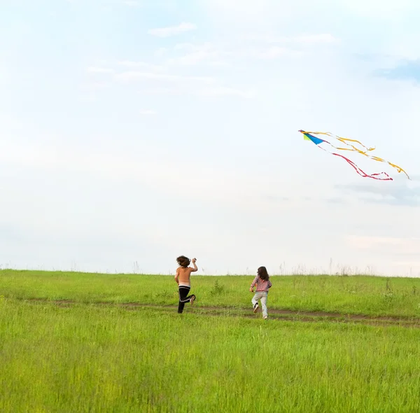 Two little girls fly a kite — Stock Photo, Image