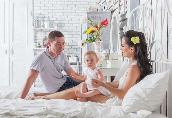 Ihana perhe istuu yhdessä sängyllä — kuvapankkivalokuva