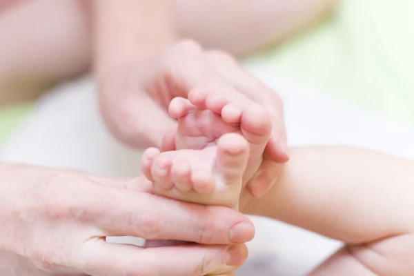 Ibu memegang dengan lembut kaki bayi — Stok Foto