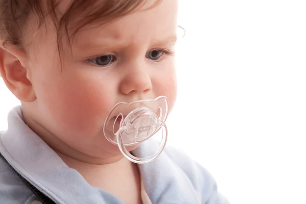 Portrait of displeased baby boy with pacifier — Stock Photo, Image