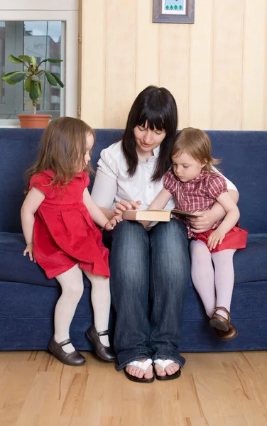 Mère lisant un livre à ses petites filles — Photo