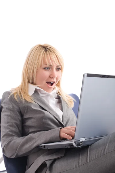 Verblüffte Geschäftsfrau mit Laptop im Stuhl über Weiß — Stockfoto