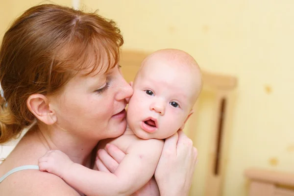 Mama delikatnie trzymając dziecko w ręce — Zdjęcie stockowe