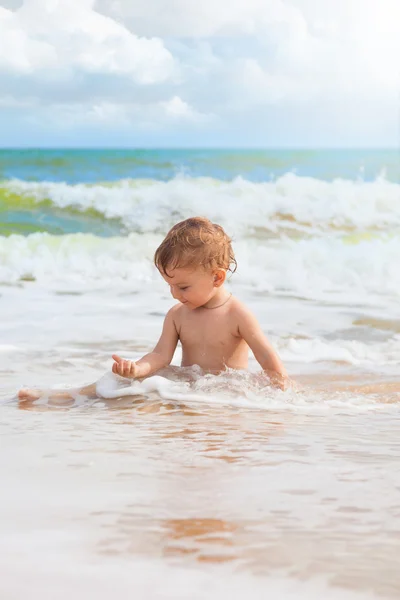 Menina brincando com areia no mar — Fotografia de Stock
