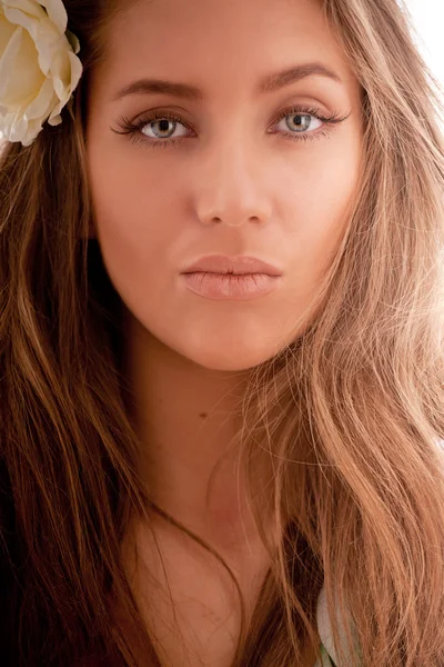 Ritratto di attraente ragazza dai capelli castani con fiore in capelli — Foto Stock