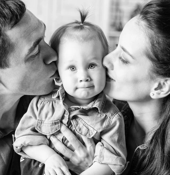 BW portrait of mother and father kissing his year-old daughter — Stock Photo, Image