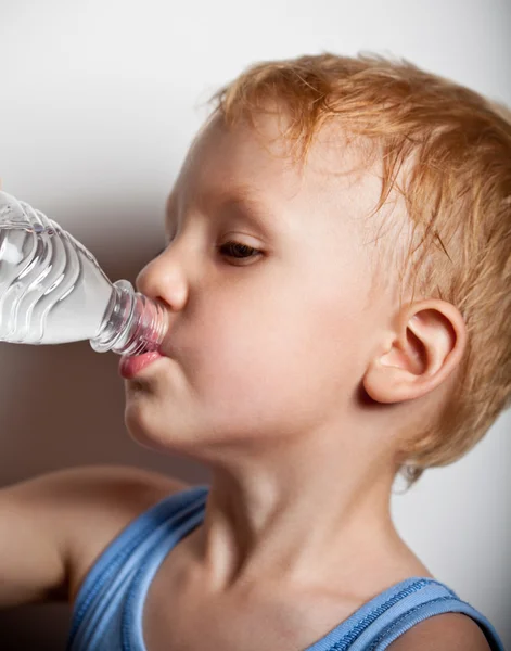 Quench dahaga. Anak itu minum air mineral dari botol — Stok Foto