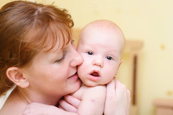 Mama delikatnie trzymając dziecko w ręce — Zdjęcie stockowe