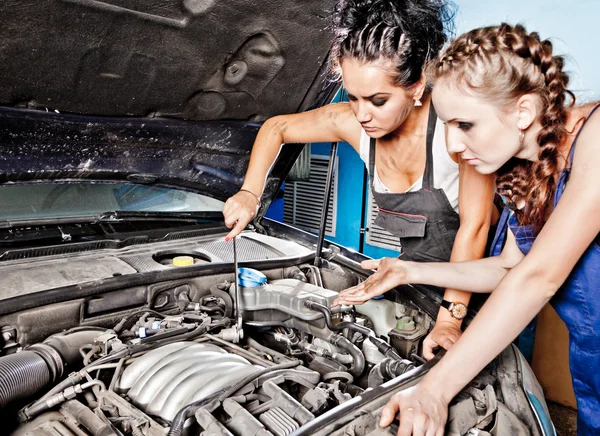 Two female auto mechanic repairing a car — Stock Photo, Image