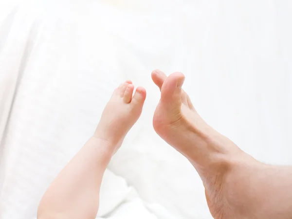 Baby's leg toching to father's leg — Stock Photo, Image