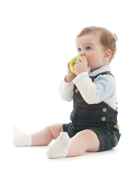 Adorable baby boy sit and eat green apple over white — Stock Photo, Image