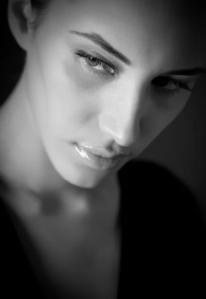 BW portrait of attractive melancholic brunette girl over black — Stock Photo, Image