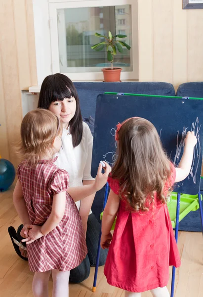 Preparar para a série escolar. Mãe ensinando suas filhas — Fotografia de Stock