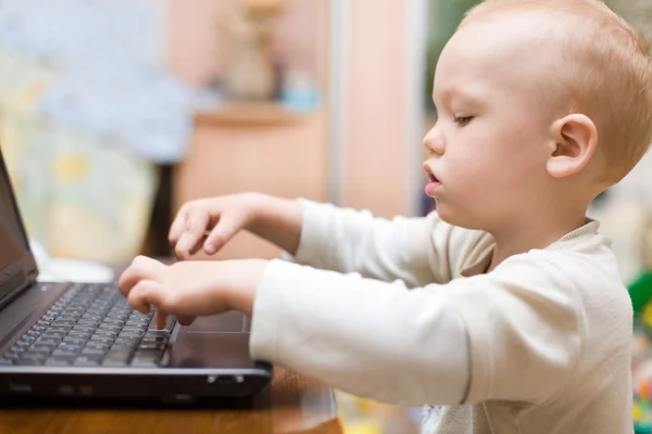 Kleiner Junge tippt zu Hause Text auf Laptop — Stockfoto