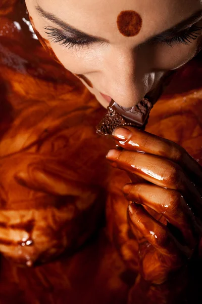 Mujer cubierta de chocolate derretido sabe barra de chocolate y disfrutar — Foto de Stock