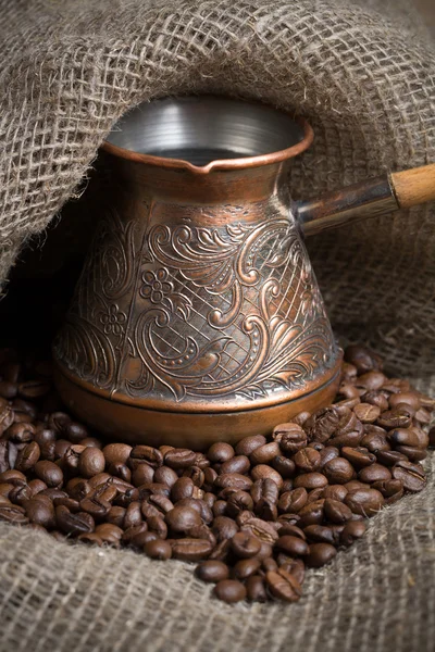 Cezve mit frisch gerösteten Kaffeebohnen auf Sacktuch lizenzfreie Stockbilder