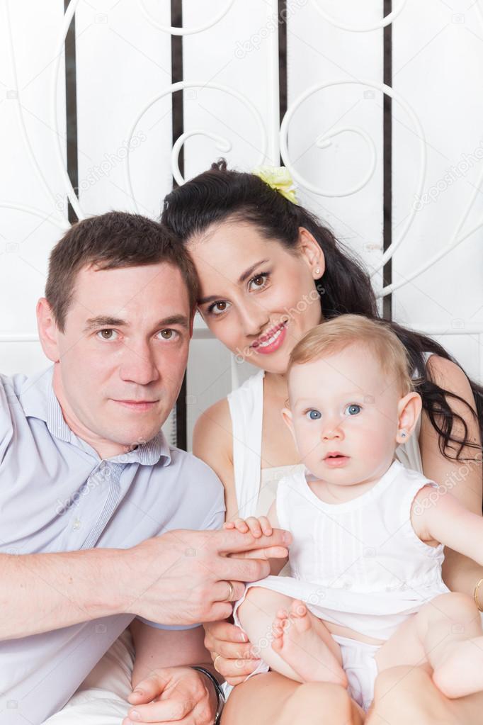 Lovely family sitting together on the bed