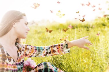  Girl sitting in a meadow in a swarm of flitting butterflies. clipart