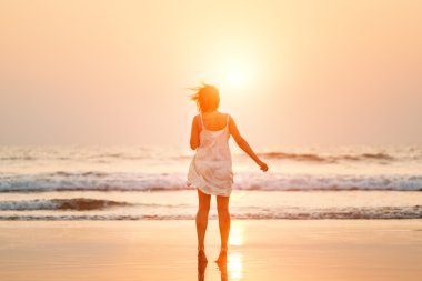 gün batımında sahilde kadın