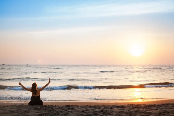 Женщина на пляже на закате — стоковое фото